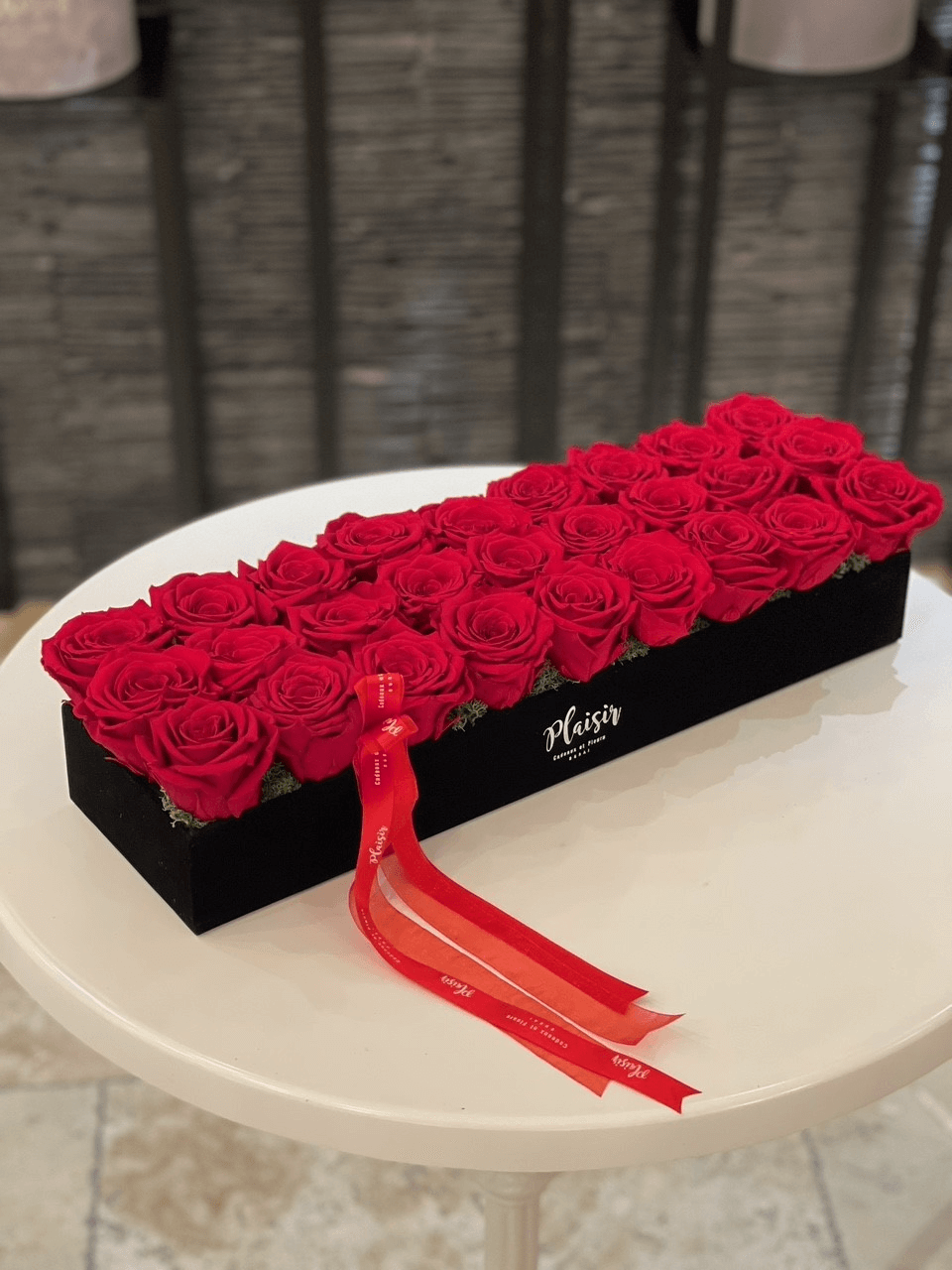 Fresh roses in a box arrangement in a glamorous velvet tray